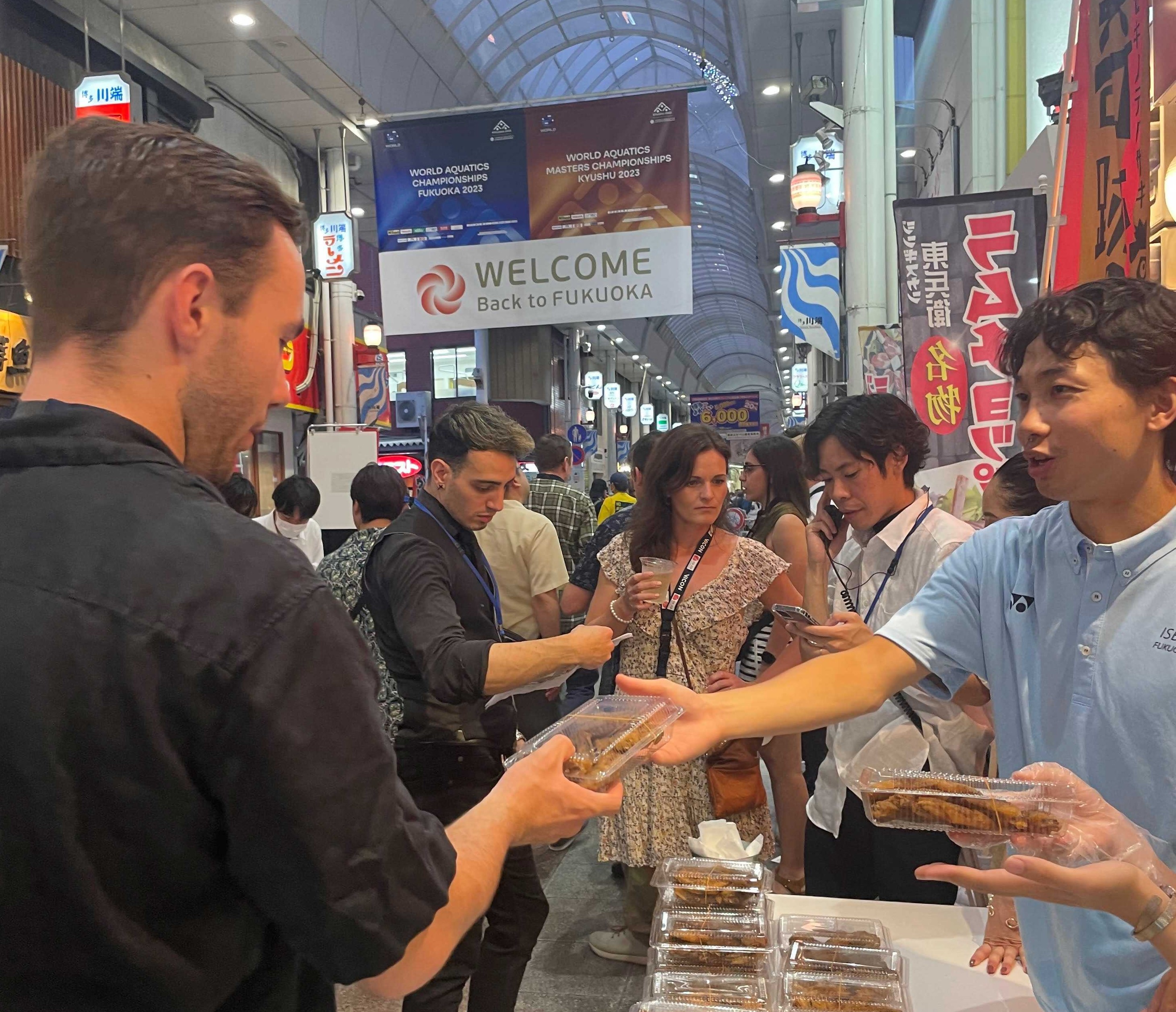 世界水泳の外国人来訪者へ学生が観光案内をしている様子