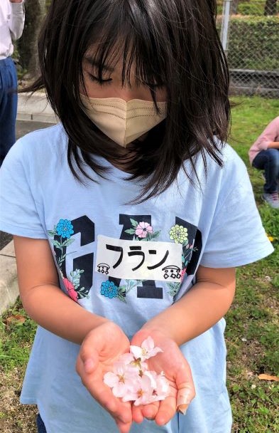 子どもの手のひらに花びら１