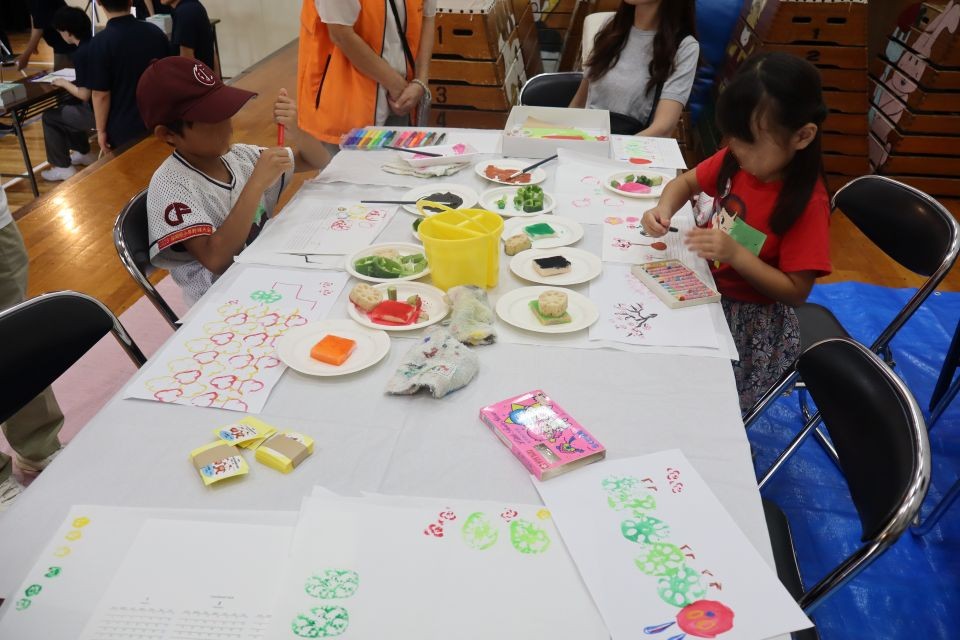 やさいスタンプでカレンダーを作る子どもたちの写真