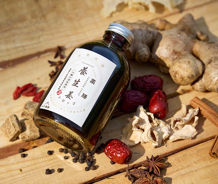写真：生姜と薬膳素材を背景に写した養生姜シロップの商品