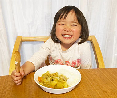 写真：カレーを前に笑顔を見せる女の子