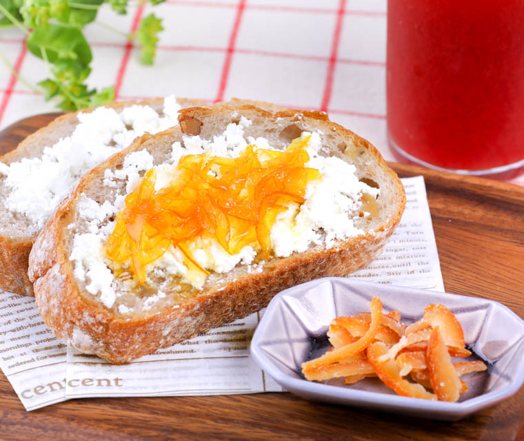 写真：クリームチーズと甘夏マーマレードをのせたパンと、ブラッドオレンジピール、ブラッドオレンジジュースが並んだ食卓