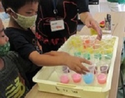 色がついたスライムのカップを選ぶ子どもたちの画像