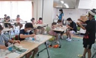 透明な洗濯糊などに絵具で色をつける子どもの画像