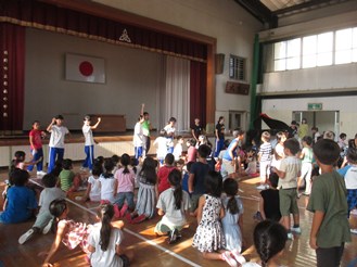 ジュニアリーダーの中学生が子どもたちの前に立って声をかける様子
