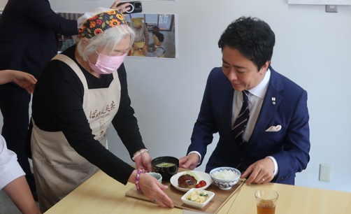 市長にランチを運んでくる利用者