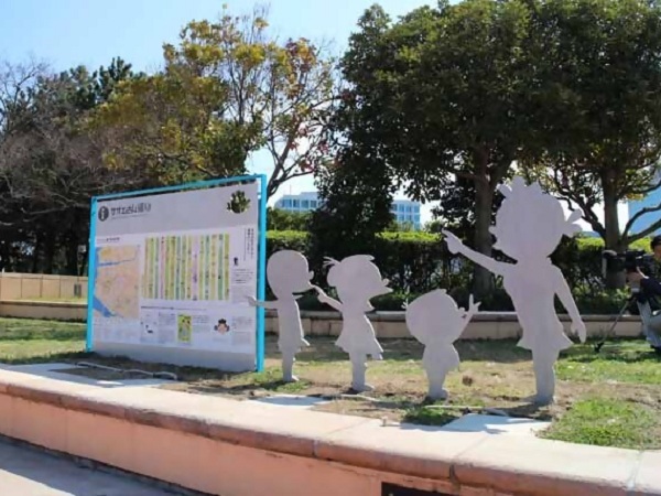 シーサイドももち海浜公園にある案内看板と、サザエさん一家のシルエットのオブジェ