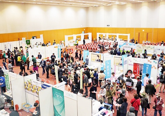 過去のイベントの様子「様々なブースと人々で賑わっている、会場を上から見た写真」