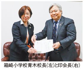 箱崎小学校青木校長(左)と印会長(右)の写真