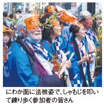 にわか面に法被姿で、しゃもじを叩いて練り歩く参加者の皆さん