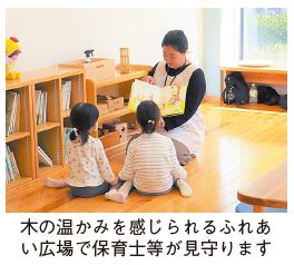 木の温かみを感じられるふれあい広場で保育士が見守りをする写真