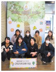 オリジナル記念撮影ボードを背景に撮影した中村学園大学教育学部の学生の写真