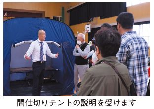 防災訓練の写真(間仕切りテントの説明を受けます)