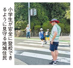 小学生が安全に投稿できるように見守る地域住民の写真