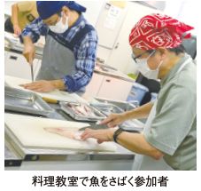料理教室で魚をさばく参加者