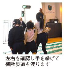 交通安全教室の写真(左右を確認し手を挙げて横断歩道を渡ります)