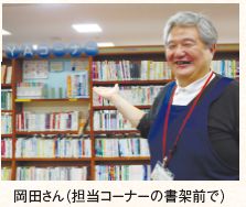 岡田さん(担当コーナーの書架前で)