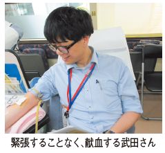 緊張することなく、献血する武田さんの写真