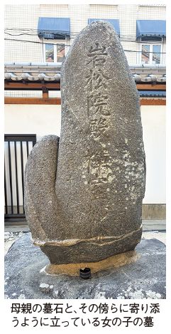 母親の墓石と、その傍らに寄り添うように立っている女の子の墓の写真