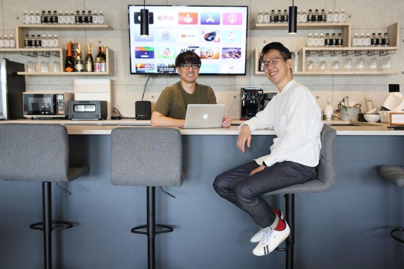 画像:社内のカフェスペースにて、黒木ヨウドウ取締役と