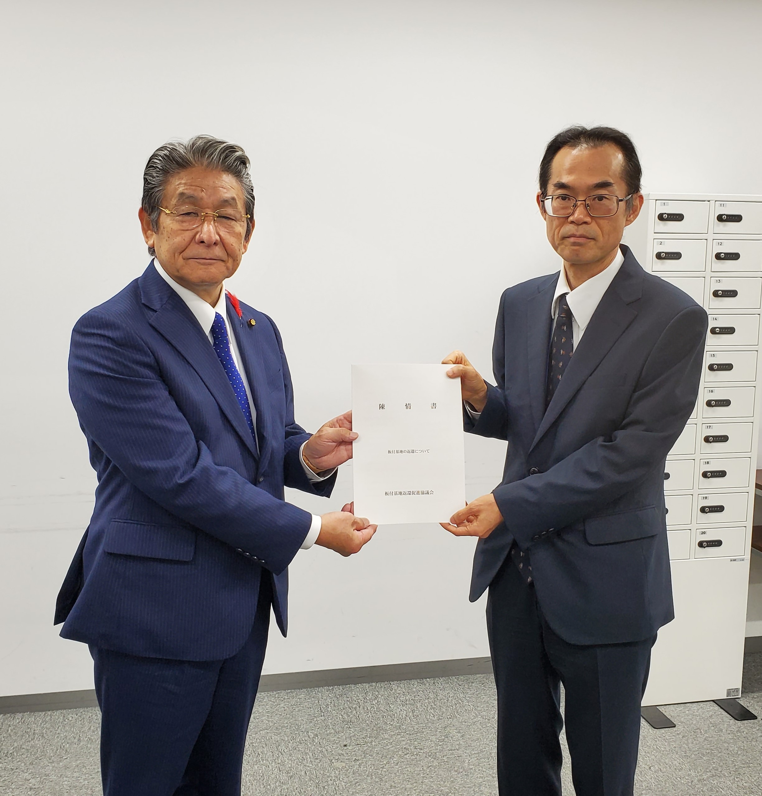 陳情書を手にする打越会長と原田課長