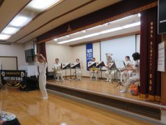 ステージ上で演奏演技をする福岡市消防音楽隊の写真