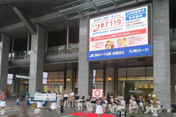 JR博多駅前広場で演奏・演技をする福岡市消防音楽隊カラーガード隊の写真