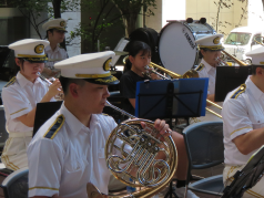 演奏をする消防音楽隊と職場体験の中学生の写真